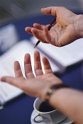 A first-person image of expressive hands with a pen and notepad