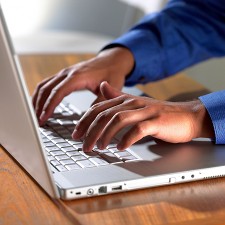 Image of writer's fingers on laptop keyboard