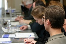 Image of employees at desk writing and typing