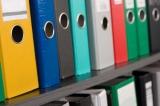 Image of different coloured folders on office shelves